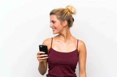 Yan bakarak cep telefonu kullanarak genç sarışın kadın