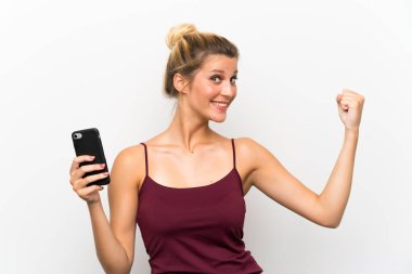 Güçlü jest yapan cep telefonu kullanan genç sarışın kadın