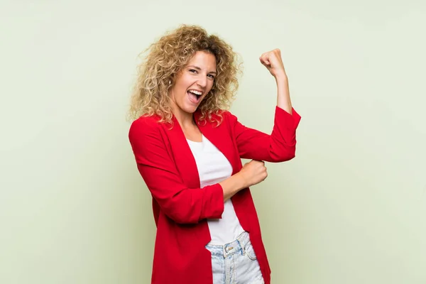 Young Blonde Woman Curly Hair Isolated Green Background Doing Strong — Stock Photo, Image