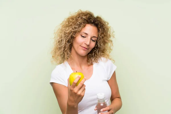 젊은 금발의 여자 와 곱슬 머리 와 a 사과 과 a 병 의 물 — 스톡 사진