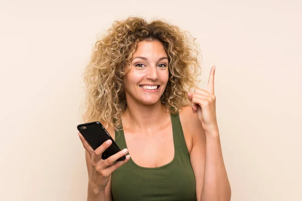 Mujer Rubia Joven Con Pelo Rizado Usando Teléfono Móvil Señalando —  Fotos de Stock