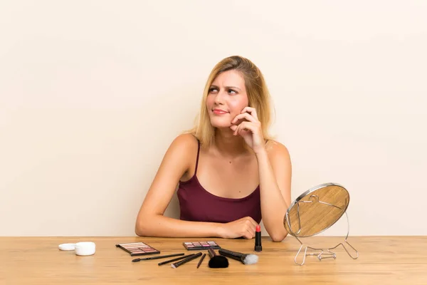 Joven Rubia Con Cosmética Una Mesa Pensando Una Idea — Foto de Stock