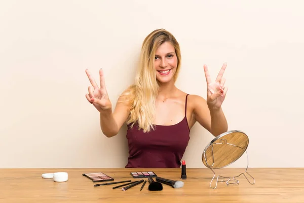 Junge Blonde Frau Mit Kosmetik Einem Tisch Lächelnd Und Zeigt — Stockfoto