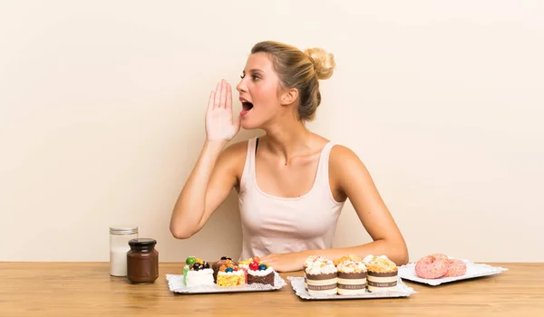 Junge Frau Mit Vielen Verschiedenen Mini Kuchen Einem Tisch Schreit — Stockfoto