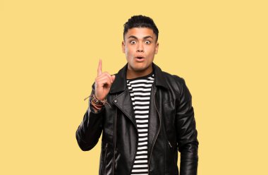 Genç adam izole arka plan üzerinde parmak işaret bir fikir düşünme