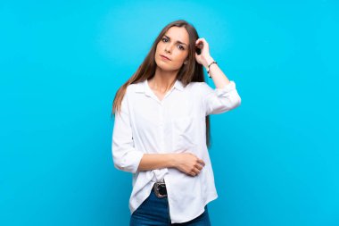 İzole edilmiş mavi arka planı olan genç bir kadın.