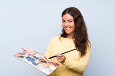 Izole mavi arka plan üzerinde genç sanatçı kadın