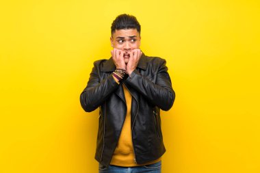 Izole sarı arka plan sinirli üzerinde genç adam ve ağız ellerini koyarak korkmuş