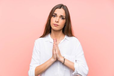 Izole pembe arka plan yalvaran üzerinde genç kadın