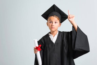 Küçük çocuk gri arka plan üzerinde bir numaralı işareti sayma mezun