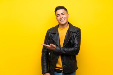 Izole sarı arka plan üzerinde genç adam doğru gülümseyerek bakarken bir fikir sunan