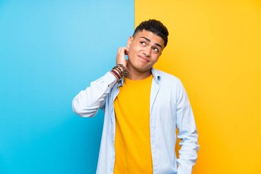 Izole renkli arka plan üzerinde genç adam bir fikir düşünme