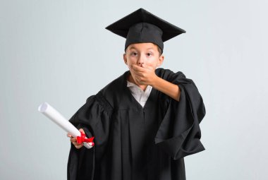 Küçük çocuk birini parmakla işaret ve gri arka plan üzerinde çok gülüyor mezun