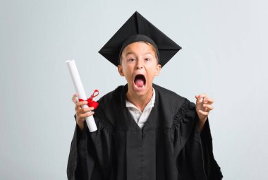 Küçük çocuk gri arka plan üzerinde öfkeli jest kızgın rahatsız mezun