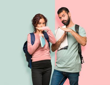 Renkli duvarda bir hareket durdurmak için eliyle stop jest yapma sırt çantaları ve kitapları ile iki öğrenci