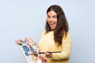 Izole mavi arka plan üzerinde genç sanatçı kadın