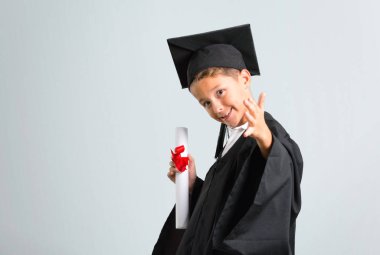 Küçük çocuk gri arka plan üzerinde iyi bir anlaşma sonra el sıkışma mezun