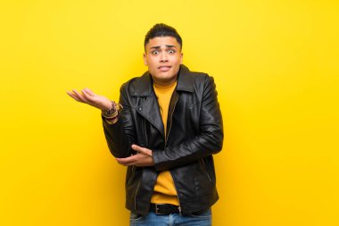 Izole sarı arka plan üzerinde genç adam bir şey anlamak için mutsuz