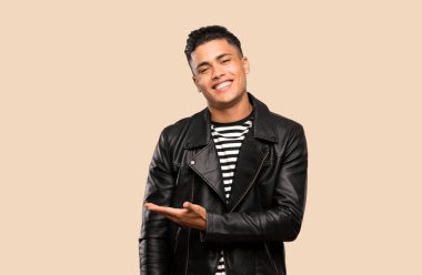 Genç adam izole arka plan üzerinde gülümseyerek bakarken bir fikir sunan