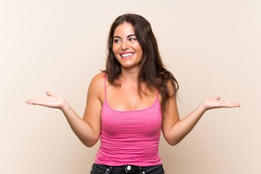 İzole edilmiş beyaz arka planı olan genç bir kadın iki eliyle kopyalama alanı tutuyor.