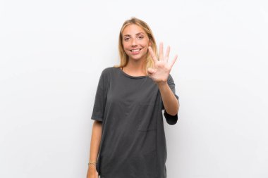 Izole beyaz arka plan üzerinde Sarışın genç kadın mutlu ve parmakları ile dört sayma
