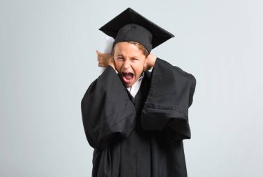 Küçük çocuk gri arka plan üzerinde elleri ile her iki kulak kapsayan mezun