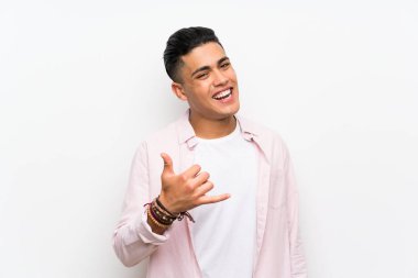 Izole beyaz duvar üzerinde telefon jestyapma genç adam