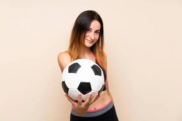 Giovane donna sportiva su sfondo isolato in possesso di un pallone da calcio — Foto Stock