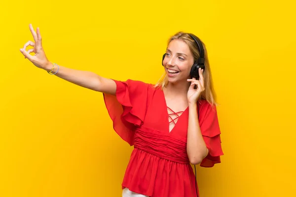 Mujer Joven Rubia Sobre Fondo Amarillo Aislado Escuchando Música Con — Foto de Stock