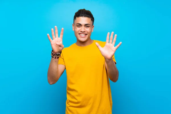 Mladý Muž Žlutou Košilí Přes Izolované Modré Pozadí Počítání Devět — Stock fotografie
