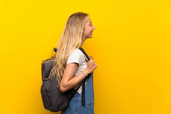 Blonde Junge Frau Über Isoliertem Gelben Hintergrund Mit Rucksack — Stockfoto