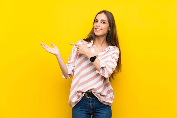 Young Woman Isolated Yellow Background Holding Copyspace Imaginary Palm Insert — Stock Photo, Image