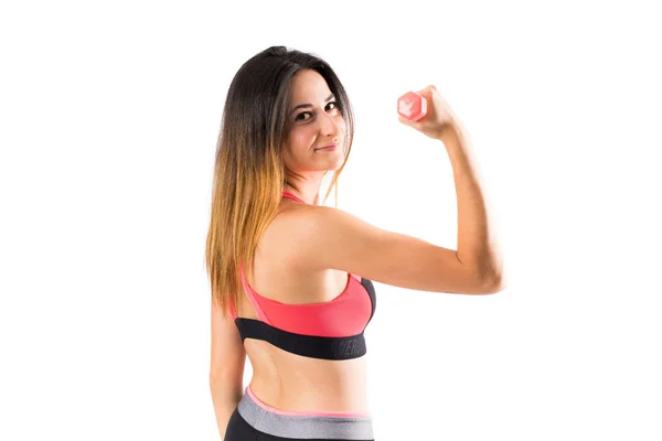 Mujer deportiva joven sobre fondo aislado haciendo levantamiento de pesas — Foto de Stock