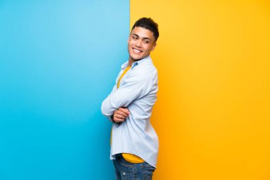 Izole renkli arka plan gülen üzerinde genç adam