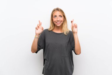 Parmakları geçiş ve en iyi dilek ile izole beyaz arka plan üzerinde Sarışın genç kadın