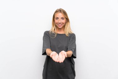 Bir reklam eklemek için avuç üzerinde copyspace hayali tutan izole beyaz arka plan üzerinde Blonde genç kadın