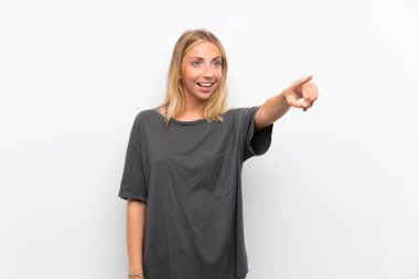 Izole beyaz arka plan üzerinde Sarışın genç kadın uzağa işaret