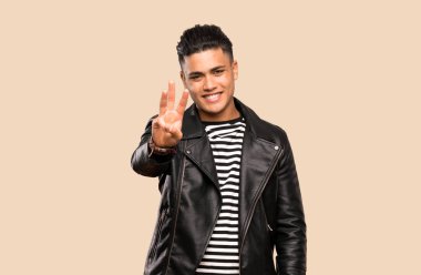 Genç adam mutlu ve izole arka plan üzerinde parmakları ile üç sayma