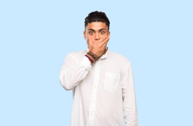 Renkli arka plan üzerinde elleri ile ağız kapsayan genç adam