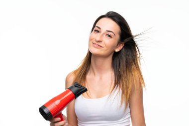 Izole arka plan üzerinde saç kurutma makinesi ile genç kadın