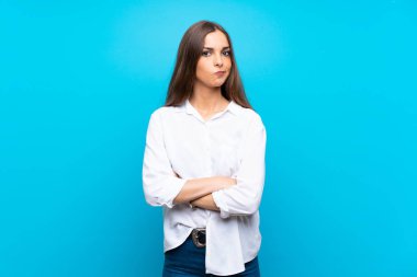 Soyutlanmış mavi arka planda genç bir kadın üzgün hissediyor