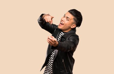 Genç adam izole arka plan üzerinde gülümserken size parmak işaret