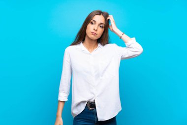 Hayal kırıklığı ve anlayış değil bir ifade ile izole mavi arka plan üzerinde genç kadın