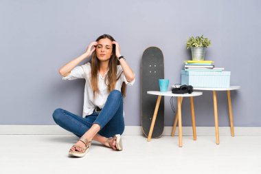 Genç kadın katta mutsuz ve bir şey ile sinirli oturuyor. Negatif yüz ifadesi