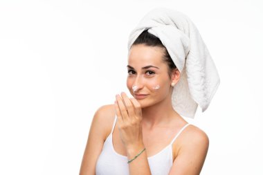 Izole beyaz arka plan üzerinde nemlendirici ile genç kadın