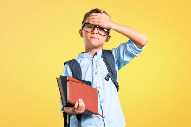 Sırt çantası ve gözlük sarı arka plan üzerinde elleri ile gözleri kapsayan öğrenci çocuk