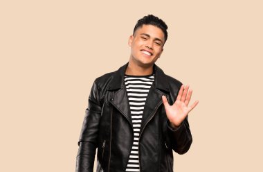 Genç adam izole arka plan üzerinde mutlu ifade ile el ile selamlama