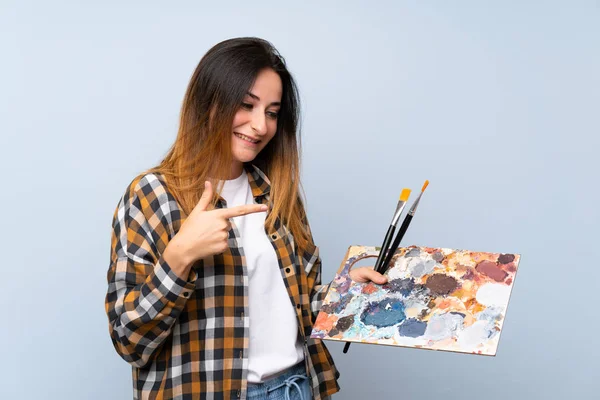 Jovem Pintor Mulher Sobre Fundo Azul Isolado Apontando — Fotografia de Stock