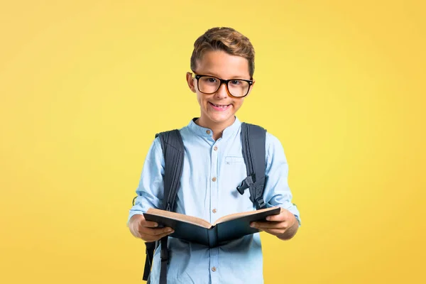 Schüler Mit Rucksack Und Brille Der Ein Buch Auf Gelbem — Stockfoto