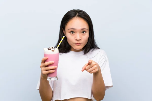 Έφηβος Ασιατικό Κορίτσι Κρατώντας Ένα Μιλκσέικ Φράουλα Έκπληκτος Και Δείχνοντας — Φωτογραφία Αρχείου